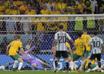 Lionel Messi memerhatikan bola rembatannya melepasi jangkauan penjaga gol Australia dalam saingan kalah mati Piala Dunia di Doha, semalam. Argentina menang 2-1. - AFP