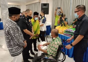 MIOR Faridalathrash Wahid (dua dari kiri) menyantuni salah seorang penerima sumbangan di Mes Pegawai Kanan Polis di Ipoh, Perak hari ini.