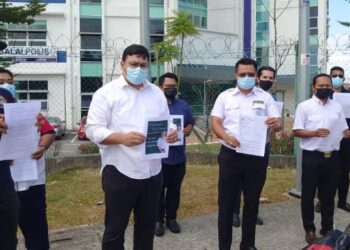 MOHD. Hairi Mad Shah (depan tiga kanan) menunjukkan laporan polis yang dibuat pihaknya terhadap Tommy berhubung bukunya di IPD Johor Bahru Selatan, Johor. - FOTO/KHAIRUL MOHD. ALI