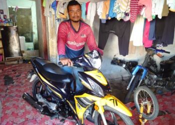 AMRAN Ronggi bersama motosikal yang disumbangkan oleh Ustaz Ebit Lew ketika ditemui di rumahnya di Kampung Kuala Masai, Pasir Gudang, Johor hari ini. - FOTO/KHAIRUL MOHD. ALI