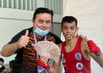 RIFDEAN Masdor (kanan) bersama jurulatihnya, Bernard Radin selepas menjuarai Kejohanan Muay Thai Dunia 2021 di Bangkok, kelmarin.