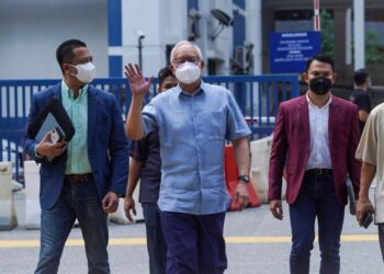 NAJIB Tun Razak (tengah) melambai ke arah wakil media ketika keluar dari IPD Dang Wangi selepas selesai membuat laporan polis berhubung cubaan menyembunyikan bukti penting berkaitan 1MDB di Kuala Lumpur, hari ini. - UTUSAN/MUHAMAD IQBAL ROSLI