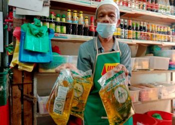 ABDUL Rahman Ahmad menunjukkan minyak masak yang kekal dijual pada harga RM2.50 sepeket di kedainya di Pasar Awam Bayan Baru, Georgetown, Pulau Pinang, semalam. - UTUSAN/NOOR HASLIZA NUSI