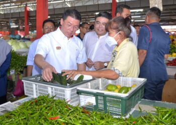 NGA Kor Ming (kiri) beramah mesra bersama peniaga ketika melawat Pasar Besar Teluk Intan hari ini. - UTUSAN/ZULFACHRI ZULKIFLI