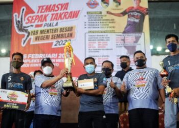 AMINUDDIN Harun (dua, kiri) dan Wan Mohd. Husni (empat dari kiri) menyampaikan piala dan hadiah kepada pemenang kategori veteran pada Temasya Sepak Takraw Piala Menteri Besar Negeri Sembilan di Paroi, Seremban baru-baru ini. - UTUSAN/MOHD. SHAHJEHAN MAAMIN.