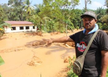 HAIRI Othman menunjukkan lokasi dia sedang membuat kerja-kerja membina pagar sebelum dihanyutkan air berlumpur dalam kejadian ban kuari pecah di Kampung Keru Hulu, Tampin, Negeri Sembilan, kelmarin.-UTUSAN/NOR AINNA HAMZAH