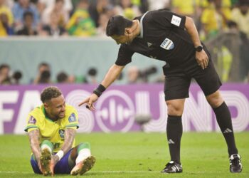 NEYMAR menahan kesakitan sambil diperhatikan oleh pengadil, Alireza Faghani (kanan) ketika membantu Brazil menentang Serbia dalam aksi Kumpulan G, Piala Dunia 2022 di Stadium Lusail, Doha semalam. - AFP