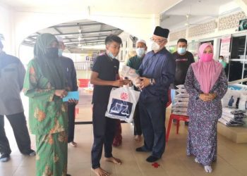 NOH Omar (dua dari kiri) menyerahkan sumbangan barangan keperluan harian kepada salah seorang penerima di Masjid Al-Raudhah, Tanjong Karang, Selangor hari ini.