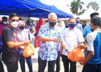 NOH Omar (tengah) menyerahkan ayam yang dijual dengan harga RM5 dekat Padang Astaka Tanjong Karang di Kuala Selangor, Selangor, hari ini. - FOTO/ABDUL RAZAK IDRIS