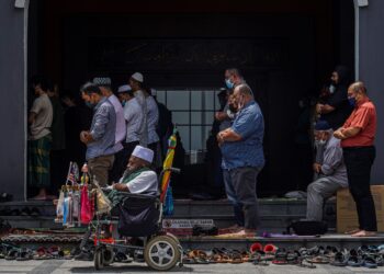 Seorang lelaki orang kurang upaya berkerusi roda menunaikan solat di Masjid Jamek Kampung Baru, Kuala Lumpur. – UTUSAN/SHIDDIEQIIN ZON