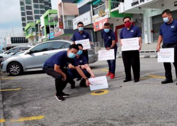 OH Tong Keong (kiri) menunjukkan kawasan parkir di Persiaran Karpal Singh, Pulau Pinang yang diswastakan kepada sebuah syarikat swasta oleh kerajaan negeri.