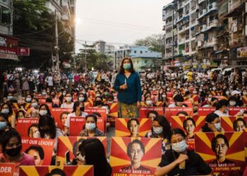 PENUNJUK PERASAAN memegang plakad memaparkan gambar Aung San Suu Kyi ketika menyertai protes membantah rampasan kuasa di Yangon. - AFP