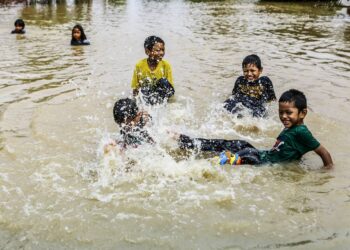 Kanak-kanak bermain air berikutan kediaman mereka yang dinaiki air banjir di Taman Saujana Meru, Klang. Hujan lebat yang berterusan dan fenomena air pasang sejak lewat petang semalam mengakibatkan banjir kilat di kawasan Meru, Klang.UTUSAN/AFIQ RAZALI