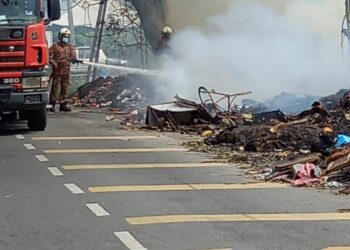 Anggota Jabatan Bomba dan Penyelamat Malaysia (JBPM) memadam kebakaran sampah barangan banjir supaya tidak merebak di Taman Cempaka Sari, Bukit Raja, Selangor,  hari ini.