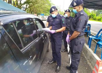 SULIZMIE Affendy Sulaiman (kiri) memeriksa kenderaan dalam sekatan jalan raya di Kilometer 126, Taman Universiti di Tanjung Malim, Perak. - IHSAN PDRM