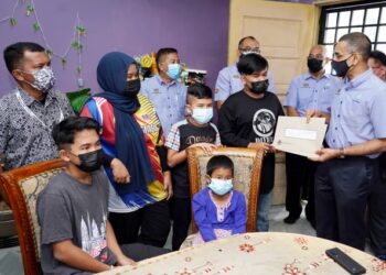 MOHAMMED Azman Aziz Mohammed (kanan) menyampaikan faedah Perkeso kepada anak-anak Allahyarham Benyajeed Bernie dan Noraini Ibrahim di Bukit Beruntung, Rawang, semalam. – UTUSAN/FAUZI BAHARUDIN