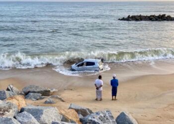 KEADAAN Perodua Axia selepas terjatuh dari tebing dan terjunam ke pesisir Pantai Mengabang Telipot di Kuala Nerus, Terengganu, hari ini.