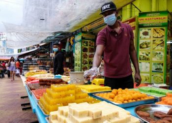 PENIAGA,  Samynathan menyusun kuih tradisi masyarakat India di gerainya di Jalan Brickfields, Kuala Lumpur, semalam. – Utusan/MUHAMAD IQBAL ROSLI