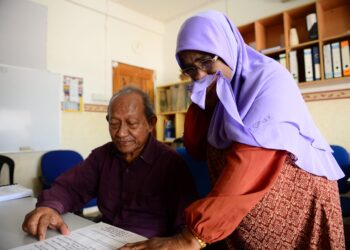 PENEROKA Felda Bukit Goh, Sarifah Jamaluddin, 69, bersama Md. Derus Yusof, 76, melihat maklumat penerimaan bayaran bauksit yang dihantar oleh LHDN di Felda Bukit Goh, Kuantan, Pahang, semalam. Sarifah yang juga ibu tunggal turut sebak apabila dimaklumkan perlu membayar cukai kepada LHDN yang dianggarkan RM100,000. - FOTO/AKIE MUSTAFA