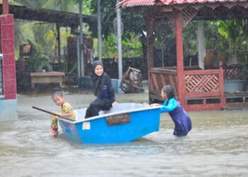 KANAK-KANAK di Kampung Sri Damai, Kuantan ini seronok bermain air di kawasan rumah mereka selepas dinaiki air akobat hujan lebat yang berterusan sepanjang hari. -UTUSAN/ SHAIKH AHMAD RAZIF