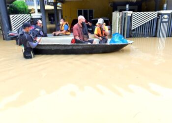 Penduduk warga emas dibantu untuk dibawa ke kawasan selamat selepas air mulai naik pada banjir di Taman Guru Kuantan di sini hari ini. -UTUSAN/SHAIKH AHMAD RAZIF