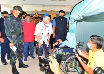 ISMAIL Sabri Yaakob mengatakan sesuatu kepada mangsa banjir dalam kalangan warga emas ketika melawat Pusat Pemindahan Sementara (PPS) di bandar Mentakab, Temerloh, Pahang- UTUSAN/ SHAIKH AHMAD RAZIF