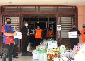 MOHD. Azhar Abdullah (dua dari kiri) menyampaikan barangan keperluan harian untuk diagihkan kepada mangsa banjir yang terjejas di Kota Tinggi, Johor semalam.