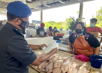 PENIAGA ayam, Ku Rusmiza Ku Desa, 40, menunjukkan resit harga ayam daripada pembekal kepada anggota penguat kuasaan PPDNHEP Perlis di Pasar Besar Arau, Perlis hari ini.- UTUSAN/NAZLINA NADZARI