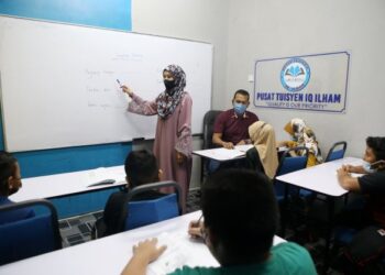 NOR AZILA AHMAD dibantu Muhammad Sahir Othman mengajar para pelajar yang mengikuti kelas tuisyen yang diusahakan pasangan suami isteri itu di Pusat Tuisyen IQ Ilham di Taman Tengku Budriah, Pauh, Arau, Perlis, semalam.- UTUSAN/SHAHIR NOORDIN