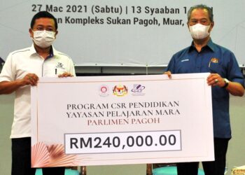 MUHYIDDIN Yassin (kanan) menerima replika cek bernilai RM240,000 daripada Pengerusi Eksekutif Yayasan Pelajaran Mara, Datuk Dr. Mohd Nizar Sudin sempena Program Jom Ke Sekolah Parlimen Pagoh dan Dun Gambir di Dewan Kompleks Sukan Pagoh, Muar, Johor. -UTUSAN/RAJA JAAFAR ALI