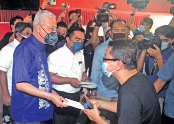 ISMAIL Sabri Yaakob menyampaikan sumbangan kepada mangsa banjir di Pusat Pemindahan Sementara (PPS) Sekolah Kebangsaan Gangsa, Durian Tunggal, Melaka, semalam. – UTUSAN/RASUL AZLI SAMAD