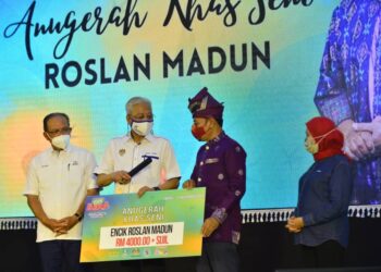 ISMAIL SABRI Yaakob (dua dari kiri) menyampaikan Anugerah Khas Seni kepada Roslan Madun pada program komuniti Keluarga Malaysia Hogoh Bera 2021 di Dewan Utama Felda Kumai di Bera, Pahang. - MINGGUAN/SHAIKH AHMAD RAZIF