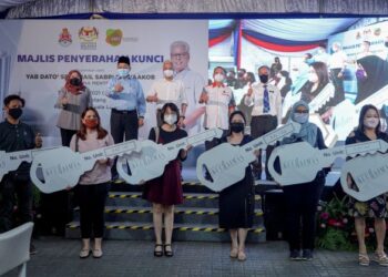 ISMAIL Sabri Yaakob (belakang, tengah) dan Shahidan Kassim (belakang, dua dari kiri) bergambar bersama sebahagian para penerima selepas sesi penyerahan kunci Residensi Kuchaimas di Kuchai Lama di Kuala Lumpur, hari ini. Turut sama, Pengerusi Aset Kayamas Sdn. Bhd., Tan Sri Chai Kin Kong (belakang, dua dari kanan). - UTUSAN/FARIZ RUSADIO 