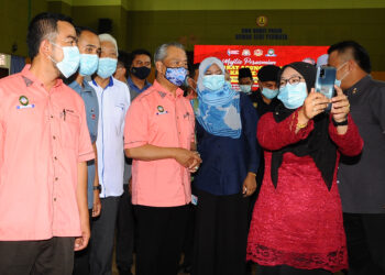 MUHYDDIN Yassin berswafoto dengan salah seorang ahli koperasi pada Majlis Perasmian Mesyuarat Koperasi Sungai Terap, Bukit Pasir, SMK Bukit Pasir, Muar. Johor. - UTUSAN/RAJA JAAFAR ALI