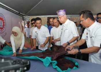 ISMAIL Sabri Yaakob  melihat kain batik yang dihasilkan usahawan tempatan pada majlis perasmian Mini Karnival Usahawan Desa (KUD) di Dataran Kerayong di Bera, Pahang, hari ini.