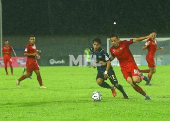 PEMAIN Sarawak United (baju merah) bersaing dengan pemain Penang FC dalam keadaan hujan di Stadium Bandaraya, Pulau Pinang malam ini. - IHSAN MFL