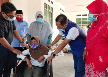 SUHAIMI Abdul Hamid (dua dari kiri) dan Zulkifli Ibrahim (kiri) bersama sebahagian daripada penerima bantuan dan modul PdPR dibawah PPKI dalam satu program bersama anjuran pengurusan SK Sungai Bakau dan pemimpin setempat di Sungai Acheh, Pulau Pinang hari ini. - UTUSAN/ISWAN SHAFIQ ISA