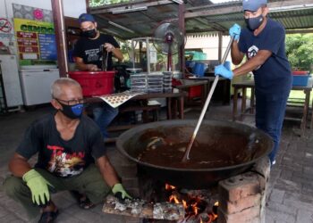 KERJA-kerja mengacau dodol dengan menggunakan kayu api sepenuhnya  memakan masa sehingga tiga jam untuk disiapkan.
-UTUSAN/ ISWAN SHAFIQ ISA