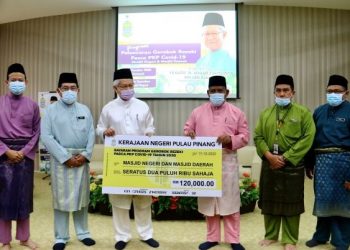 Ahmad Zakiyuddin Abd. Rahman (dua dari kanan) menyampaikan replika cek bantuan kepada Mohd. Zakuan Zakaria (kanan) ketika menyempurnakan pelancaran Gerobok Rezeki Pasca PKP Covid-19 di Masjid Negeri Pulau Pinang. - UTUSAN/AMIR IRSYAD OMAR