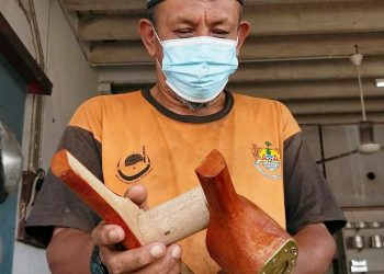 MOHD. SOBRI Yusof menunjukkan bekas membuat putu mayam yang dihasilkan daripada kayu dan sedia untuk dijual di kedainya di Kepala Batas, Pulau Pinang baru-baru ini. -UTUSAN/ISWAN SHAFIQ ISA