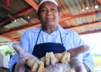 MOHAMAD Awang, 72, menunjukkan kuih dangai yang diperbuat daripada kelapa separuh masak di Kampung Lama, Kepala Batas hari ini. -UTUSAN/MOHAMMAD FIRDAUS AMRAN