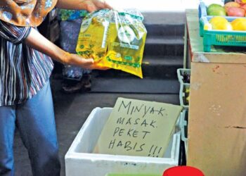 PENIAGA kedai runcit meletakkan notis kehabisan minyak masak jenis peket disebuah kedai runcit di  Flat Jalan Kedah, Georgetown. – UTUSAN/IQBAL HAMDAN