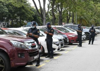 BEBERAPA anggota penguat kuasa MBSP memeriksa kenderaan yang tidak membayar caj letak kenderaan di kawasan parkir sekitar Seberang Jaya, Pulau Pinang hari ini.-UT6USAN/ ISWAN SHAFIQ ISA