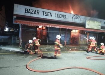 ANGGOTA bomba memadam kebakaran kedai di Bazar Tsen Loong, Jalan Taming Sari di Taiping hari ini. - FOTO/IHSAN JBPM PERAK