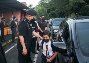 NOORZAINY Mohd. Noor menyambut pelajar yang hadir ke sekolah di Sekolah Kebangsaan Cator Avenue, Ipoh, Perak,  hari ini. - UTUSAN/ZULFACHRI ZULKIFLI