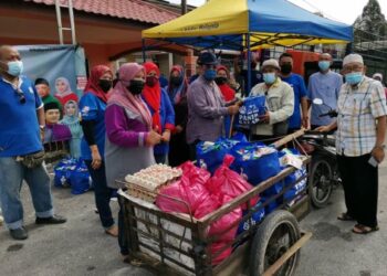 TAJUDDIN Abdul Rahman (tengah) menyampaikan bantuan prihatin rakyat di Chenderong Balai dekat Pasir Salak hari ini. - UTUSAN/AIN SAFRE BIDIN