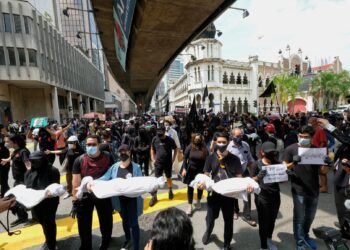 Sekumpulan peserta berpakaian hitam sedang berarak ketika protes #LAWAN di Jalan Tun Perak Kuala Lumpur, hari ini. - UTUSAN/MUHAMAD IQBAL ROSLI