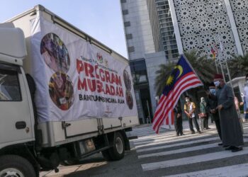 ZULKIFLI Mohamad Al-Bakri mengibarkan bendera Malaysia bagi perlepasan konvoi Program Musa'adah Covid-19 Bantuan Bencana Alam di Kompleks Islam Putrajaya hari ini. - UTUSAN/FAISOL MUSTAFA