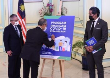 Perdana Menteri, Tan Sri Muhyiddin Yassin (tengah) bersama Menteri Kesihatan, Datuk Seri Dr. Adham Baba dan Menteri Sains, Teknologi dan Inovasi, Khairy Jamaluddin (kanan) dalam majlis pelancaran Buku Panduan Program Imunisasi Covid-19 di Putrajaya, baru-baru ini. – PMO