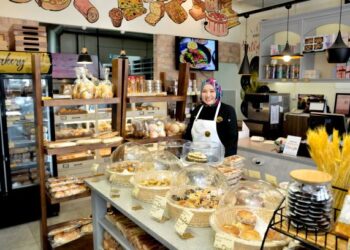 Suzana Salleh bersama roti dan kek yang dihasilkan di kedainya, 
 Bakery & Cafe, Kuala Terengganu. -UTUSAN/PUQTRA HAIRRY